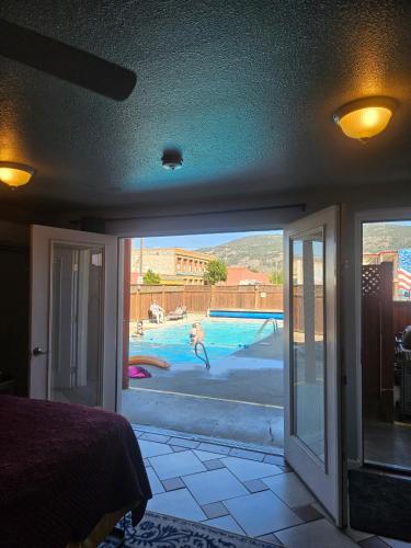 a bedroom with a view of a swimming pool at Camaray Motel in Oroville