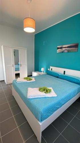a blue bedroom with a bed with towels on it at A 100 passi dal mare in Bari
