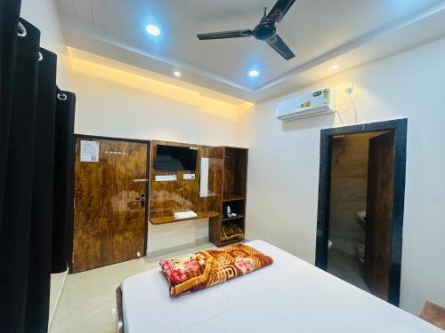 ein Schlafzimmer mit einem Bett und einem Deckenventilator in der Unterkunft Radhe Krishna Homestay in Varanasi