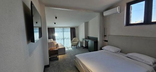ein Hotelzimmer mit einem Bett, einem Schreibtisch und einem Schlafzimmer in der Unterkunft Old Avenue Hotel in Gjumri