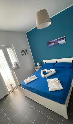 a blue bedroom with a bed with towels on it at A 100 passi dal mare in Bari