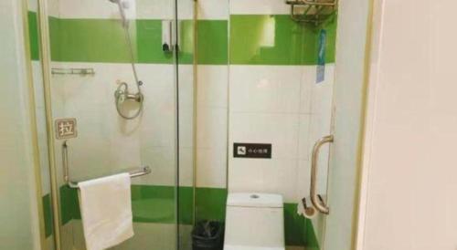 a green and white bathroom with a toilet and a shower at 7 Days Inn Changchun Zhengyang Street Changchun Park Branch in Changchun
