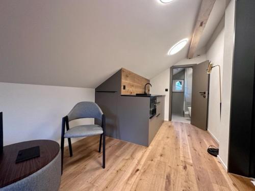 a living room with a chair and a kitchen at BERG & BERG HOTEL - Kerns Self-Check-in in Kerns