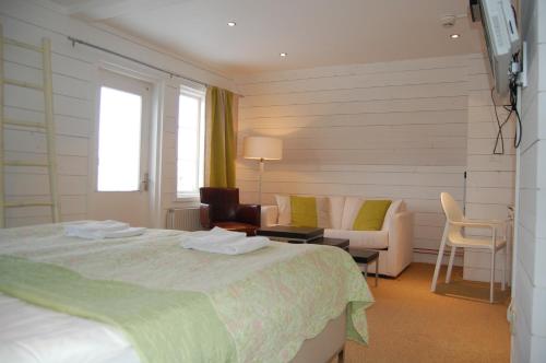 a hotel room with a bed and a couch at STF Vickleby Bo Pensionat in Färjestaden