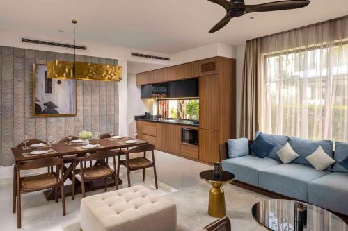 a living room with a blue couch and a table at Hoi An Royal Beachfront Villas in Dien Ban