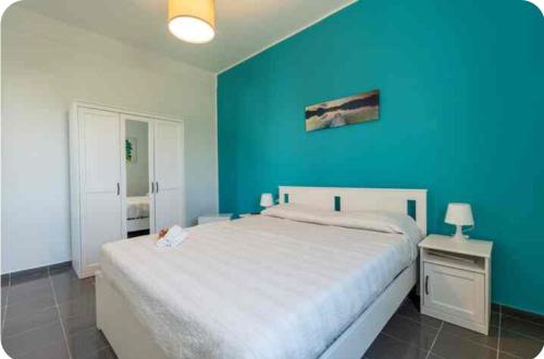 a blue bedroom with a bed and a blue wall at A 100 passi dal mare in Bari