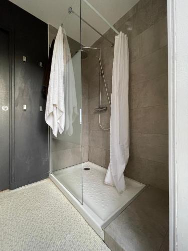 une salle de bain avec une douche avec une porte vitrée dans l'établissement Avel Mor et sa VUE imprenable sur l'île de St Cado, à Belz