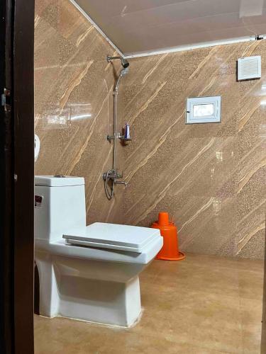 a bathroom with a toilet and a shower at Puthukkeril Heritage Home in Talavadi