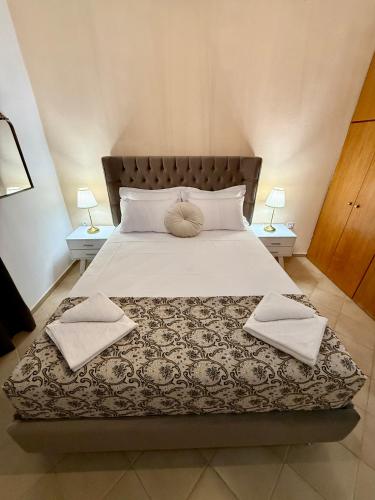 a bedroom with a large bed with two lamps at Evita Luxury Apartments in Spilia
