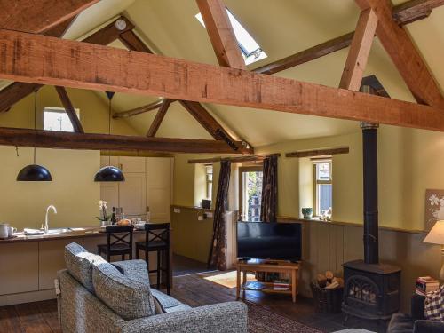 a kitchen and living room with wooden beams at The Byre in Helmsley