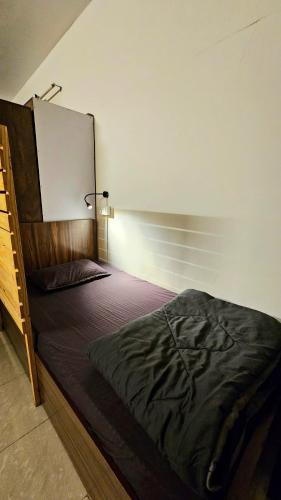 a bedroom with a large bed with a wooden headboard at Rostel Backpackers Hostel in Pune