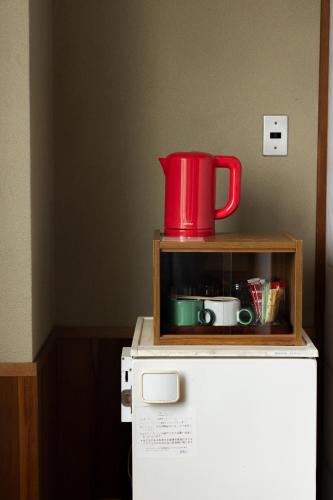 a red pitcher sitting on top of a refrigerator at Kogakuro in Myoko