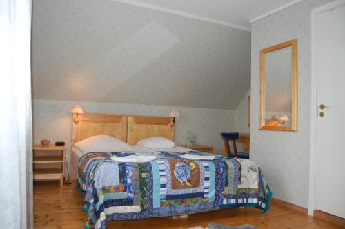a bedroom with a bed and a mirror at STF Vickleby Bo Pensionat in Färjestaden