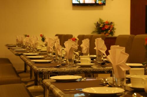 a long table with glasses and napkins on it at Sbk Park Inn in Kanchipuram