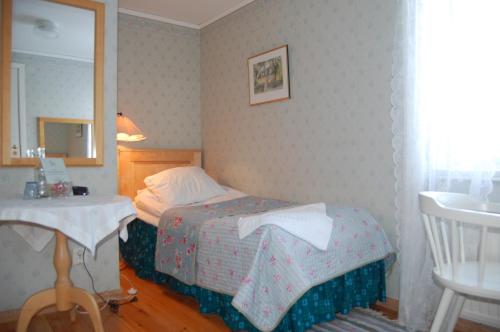 a small bedroom with a bed and a mirror at STF Vickleby Bo Pensionat in Färjestaden