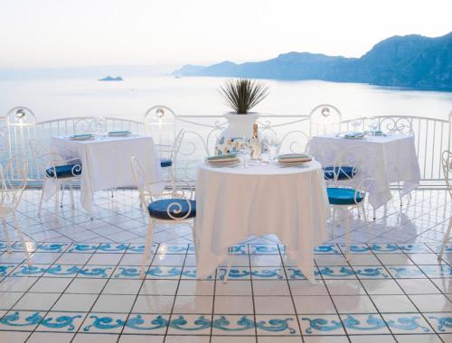 a set of tables and chairs with a view of the water at Hotel Smeraldo in Praiano