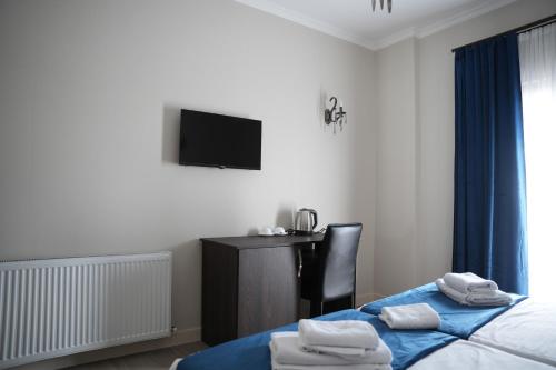 a hotel room with two beds and a television at Hotel BABU in Kutaisi