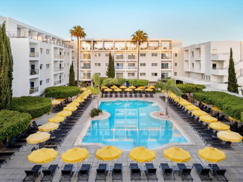 a hotel with a pool with chairs and umbrellas at Mayfair Hotel in Paphos City