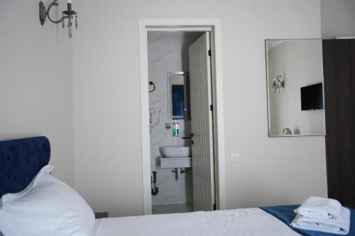 a bedroom with a bed and a bathroom with a sink at Hotel BABU in Kutaisi