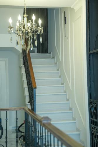 a staircase with a chandelier in a house at Hotel BABU in Kutaisi