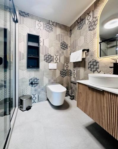 a bathroom with a toilet and a sink and a mirror at BERG & BERG HOTEL - Kerns Self-Check-in in Kerns