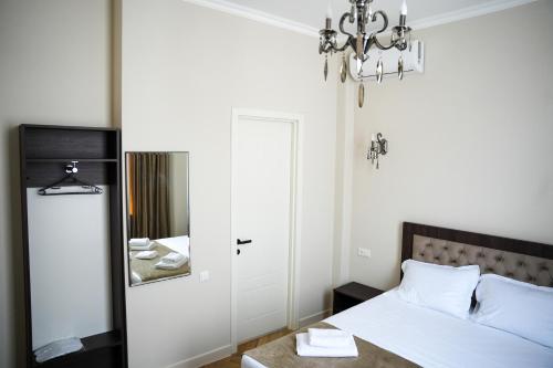 a bedroom with a bed and a mirror at Hotel BABU in Kutaisi
