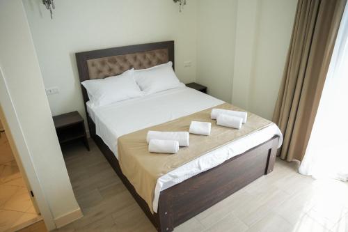 a bedroom with a bed with two towels on it at Hotel BABU in Kutaisi