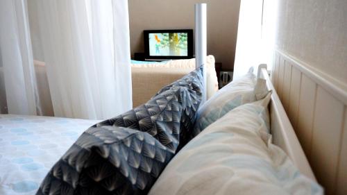 a bedroom with a bed with pillows and a television at A5 Studio in Pärnu