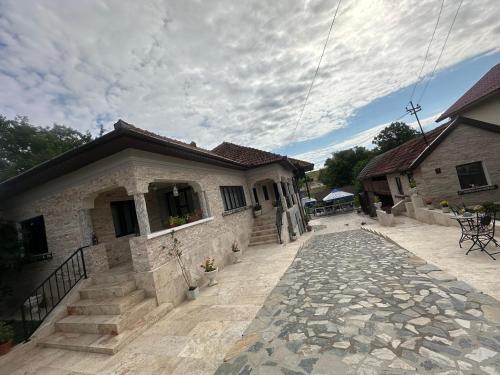 a building with a stone walkway in front of it at Agropensiune Lupu 