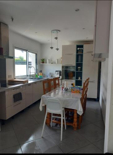 une cuisine avec une table et des chaises dans une cuisine dans l'établissement Charming house between city and countryside, à Couëron