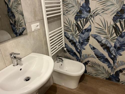 a bathroom with a sink and a toilet and a mirror at BERGAMO AIRPORT ROOMS Self check-in in Bergamo