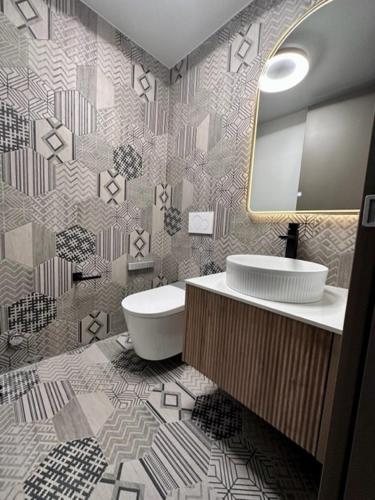 a bathroom with a toilet and a sink and a mirror at BERG & BERG HOTEL - Kerns Self-Check-in in Kerns