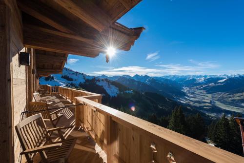 a balcony with chairs and a view of mountains at BichlAlm Berggasthof in Kitzbühel