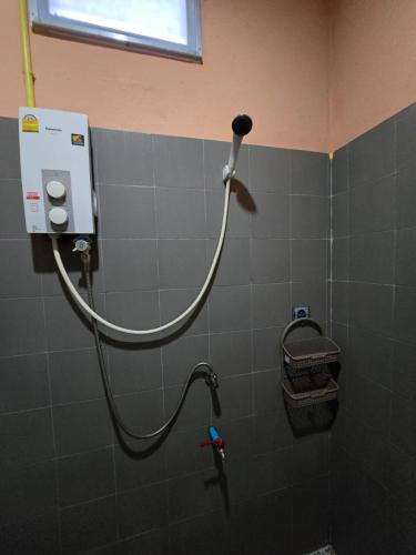 a shower in a bathroom with a hose on a wall at Cozy Modern House, Top Spot in Baan Tai