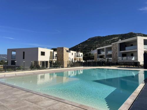 une grande piscine devant un immeuble dans l'établissement Appartement T2 vue mer et citadelle, à Calvi