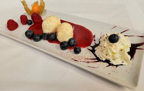 a plate of food with berries and ice cream at Hotel Reitherhof in Reith bei Seefeld