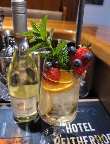 a cocktail with fruit and a bottle of wine at Hotel Reitherhof in Reith bei Seefeld