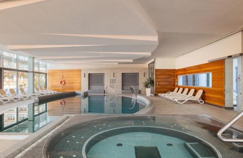 a pool in a hotel room with chairs and a swimming pool at Bluesun Hotel Elaphusa in Bol