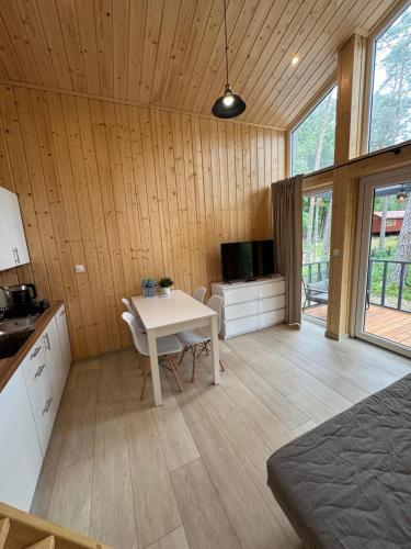 a kitchen with a table and a television in a room at Perła in Stegna