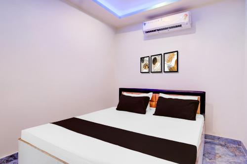a white room with a bed and a air conditioner at Hotel O The Silver Stone in Guwahati