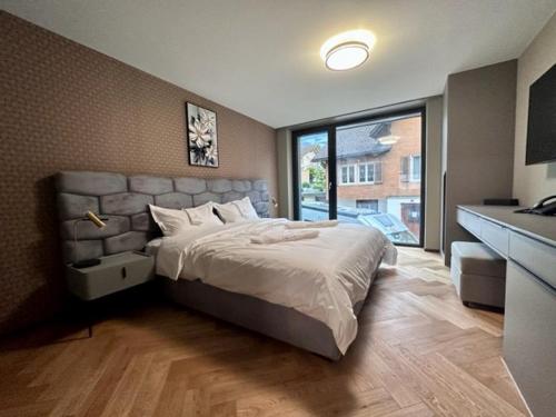 a bedroom with a large bed and a large window at BERG & BERG HOTEL - Kerns Self-Check-in in Kerns