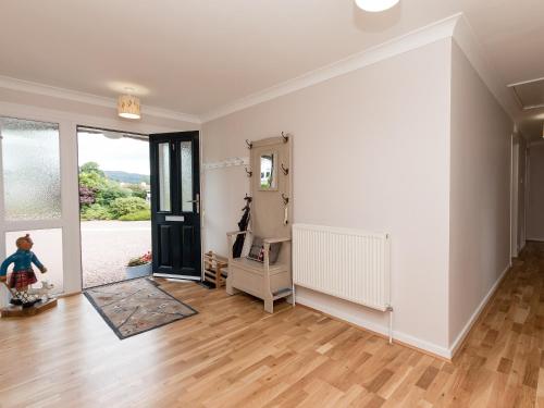an empty living room with a door and wooden floors at Sheeoch in Comrie