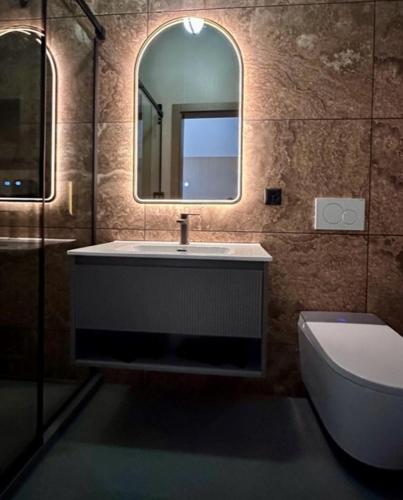 a bathroom with a sink and a mirror and a toilet at BERG & BERG HOTEL - Kerns Self-Check-in in Kerns