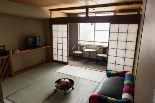 a living room with a couch and a table at Kogakuro in Myoko