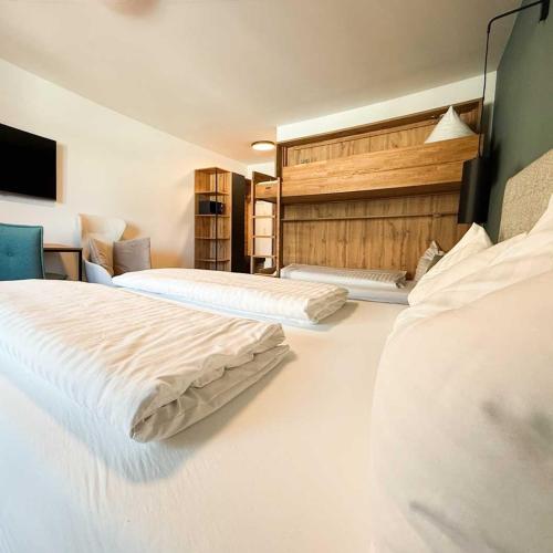 a hotel room with two beds with white sheets at Wander- und Familienhotel Erika in Wagrain