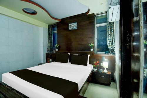 a bedroom with a bed and a clock on the wall at Hotel O Bellrose in Jaipur