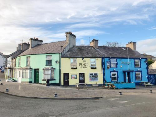 a blue and green building on the side of a street at The Barnsdale in Amlwch