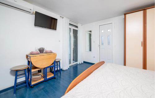 a bedroom with a bed and a table and a television at Nice Apartment In Rabac With Wifi in Rabac