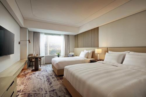a hotel room with two beds and a television at Lotte Hotel World in Seoul