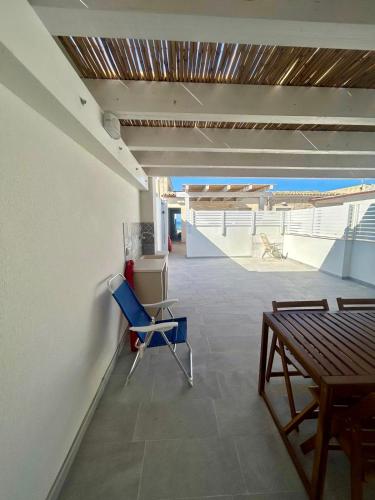 a room with a table and a blue chair at 10 passi dal mare in Donnalucata